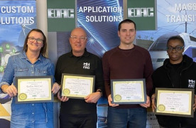 Four Edac staff smiling and holding anniversary certificates